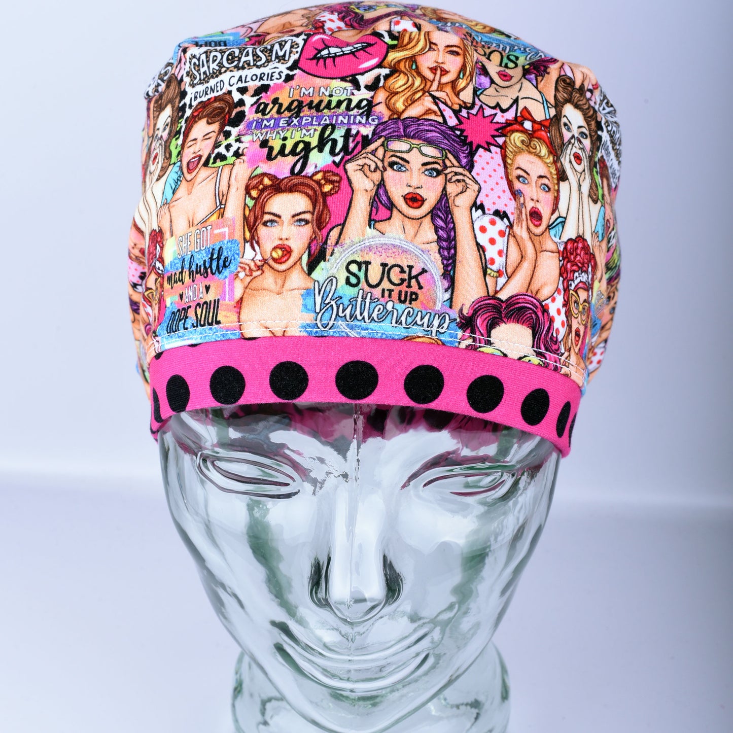 Front view of the Sassy Women scrub cap featuring retro women illustrations and vibrant polka dot pink brim detail.