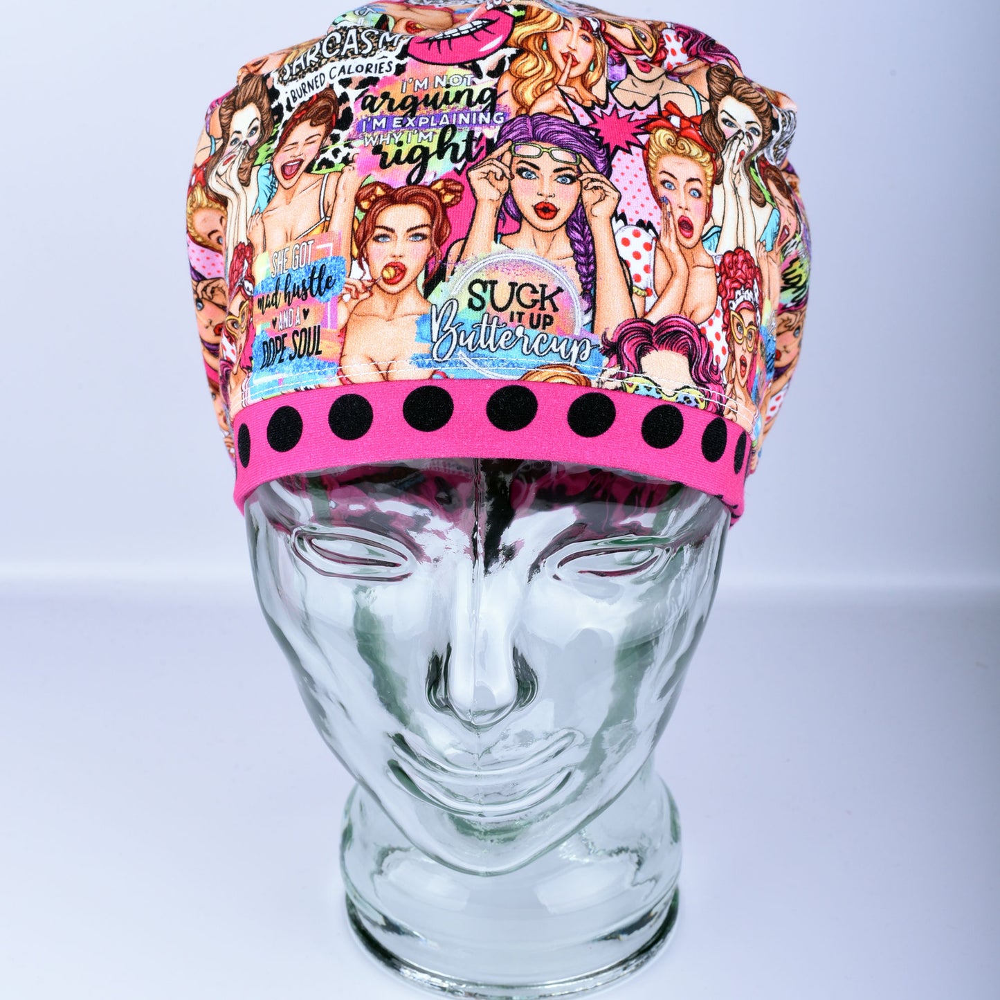 Front view of the Sassy Women scrub cap featuring retro women illustrations and vibrant polka dot pink brim detail.