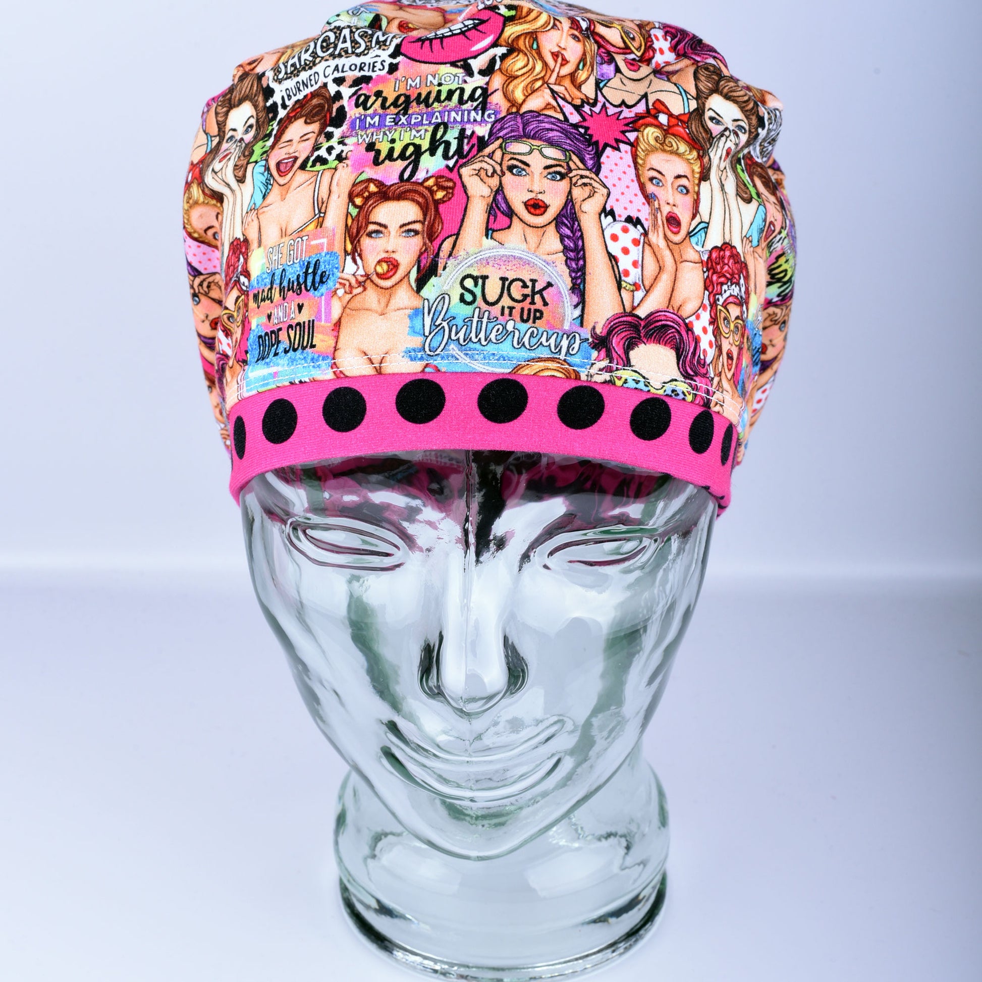 Front view of the Sassy Women scrub cap featuring retro women illustrations and vibrant polka dot pink brim detail.