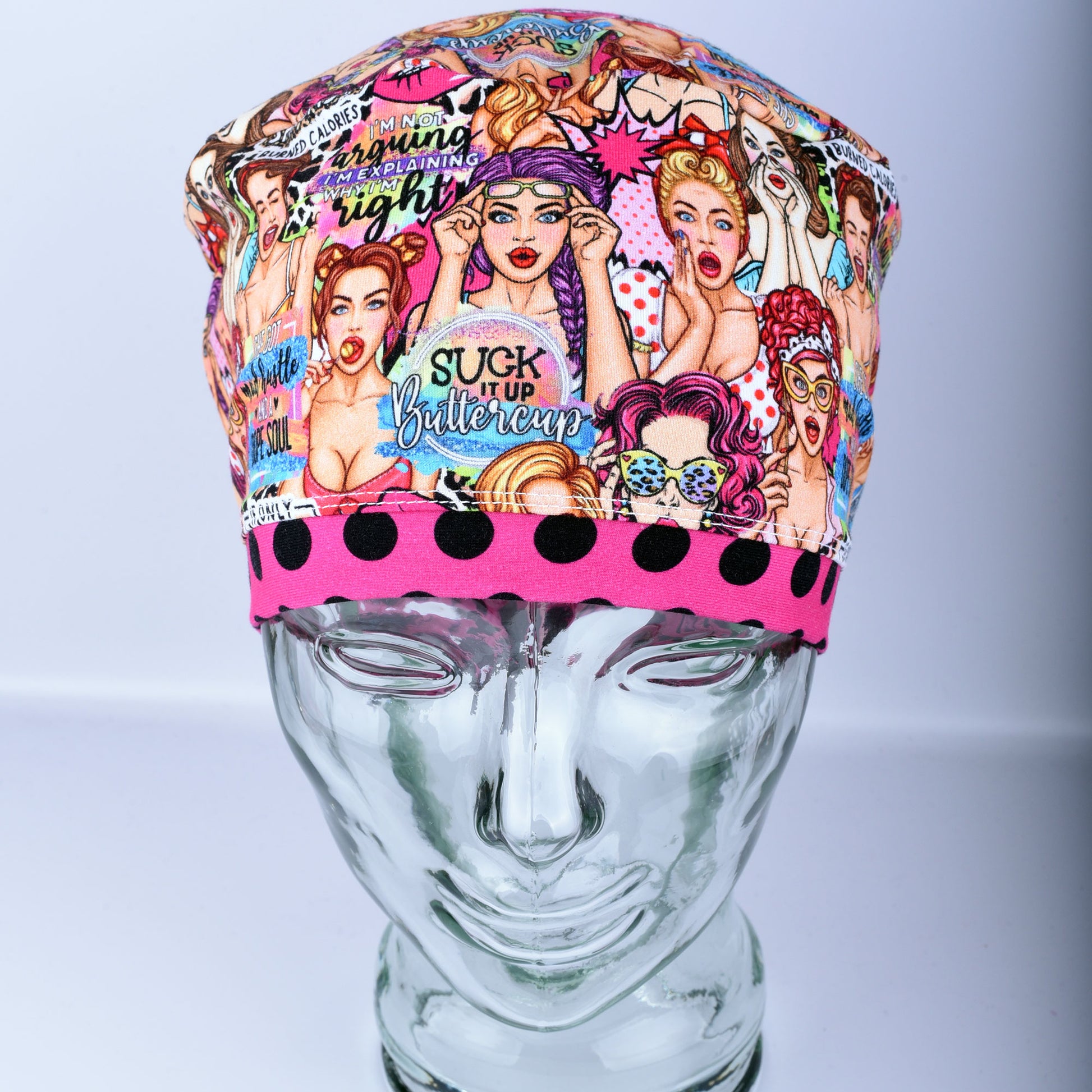 Front view of the Sassy Women scrub cap featuring retro women illustrations and vibrant polka dot pink brim detail.