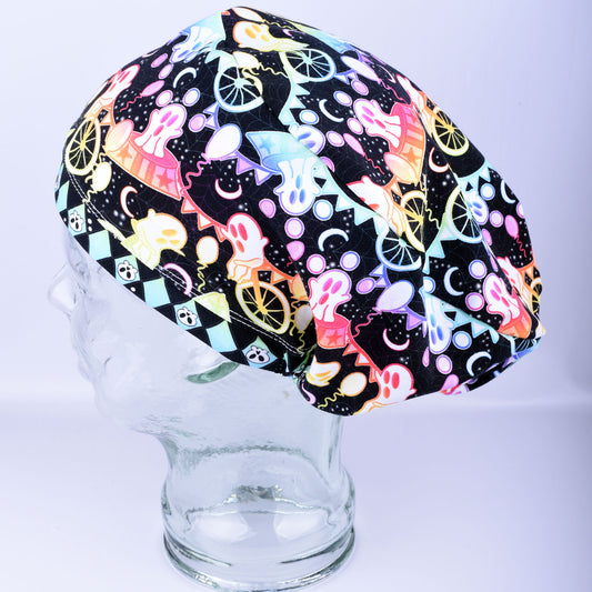 Detailed close-up of a Spooky Ghosts surgical scrub cap showcasing a colorful, festive Halloween pattern with smiling ghosts, pumpkins, and a matching pink button attached near the ear.