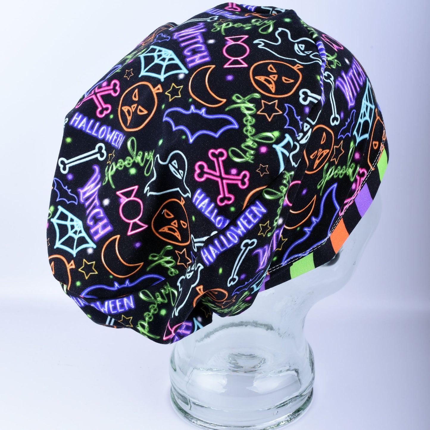 Side view of a handcrafted Neon Halloween scrub cap showing the full coverage design and elastic stretch fit.