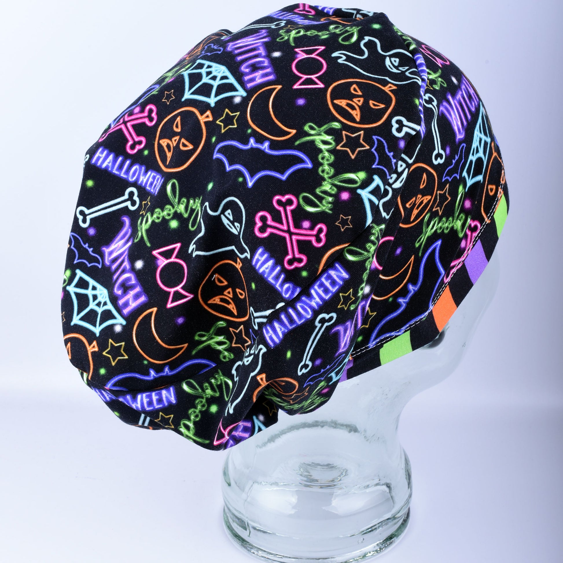 Side view of a handcrafted Neon Halloween scrub cap showing the full coverage design and elastic stretch fit.