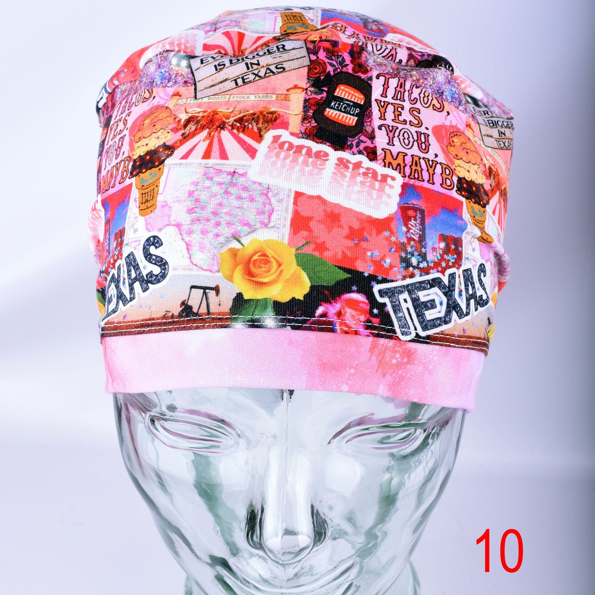A multicolor Texas-themed surgical scrub cap displayed on a clear mannequin head. The cap features a collage pattern with 'TEXAS' text, a yellow rose, a burger, and other western and Texan motifs.