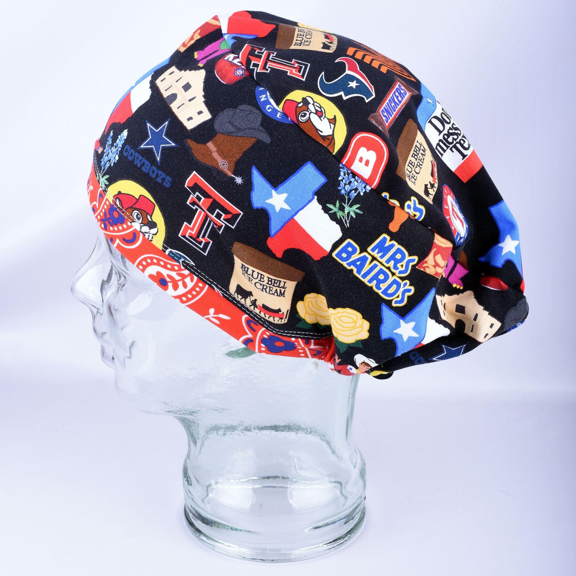 Texas Love scrub cap on a clear display mannequin head, side view showcasing the colorful Texas-themed collage print.