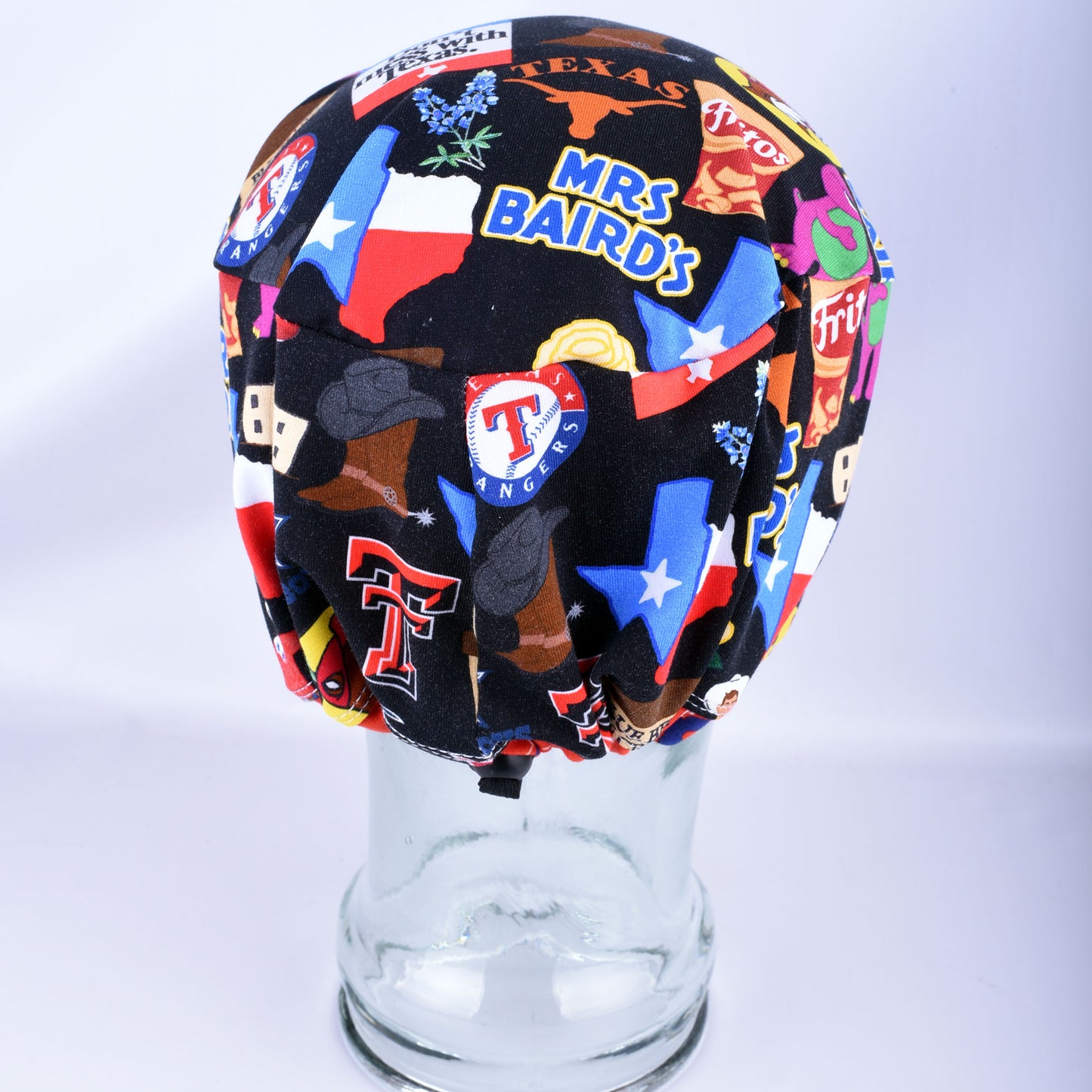 Back view of the Texas Love scrub cap on a clear display head, showing the encased elastic band and adjustable cord lock toggle for a secure fit.