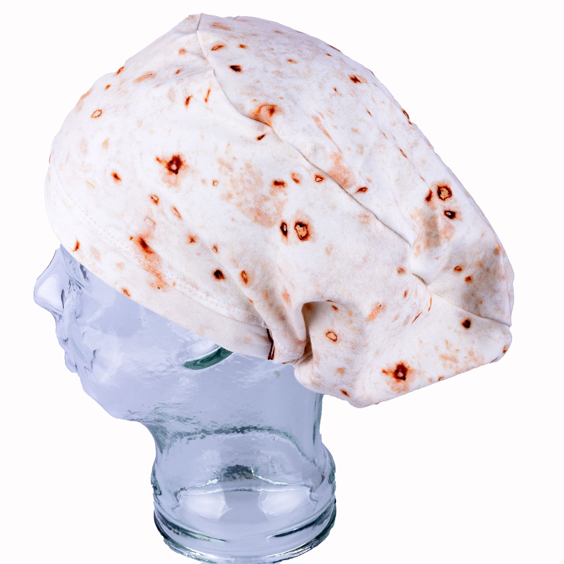 A full coverage scrub cap featuring a realistic flour tortilla print with toasted brown spots, displayed on a white mannequin head.