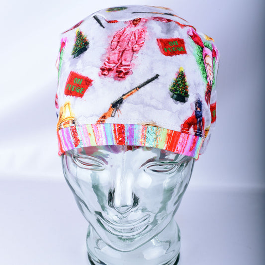 A soft stretchy scrub hat with colorful Christmas  holiday-themed designs, displayed on a clear glass mannequin head against a light gray background.