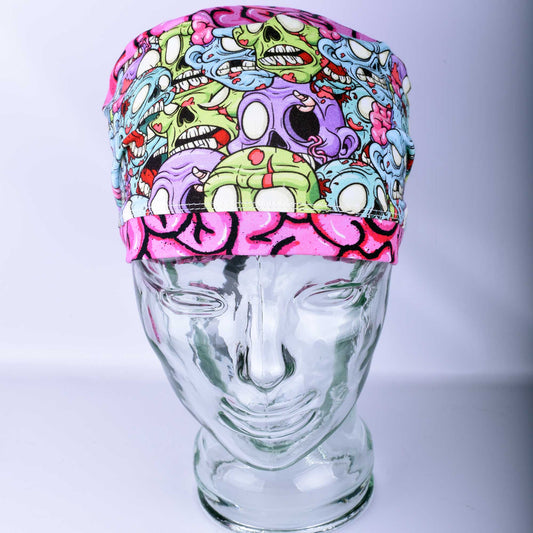 Close-up of a handcrafted cotton blend scrub cap showcasing a colorful, spooky themed graphic print with unique character details.