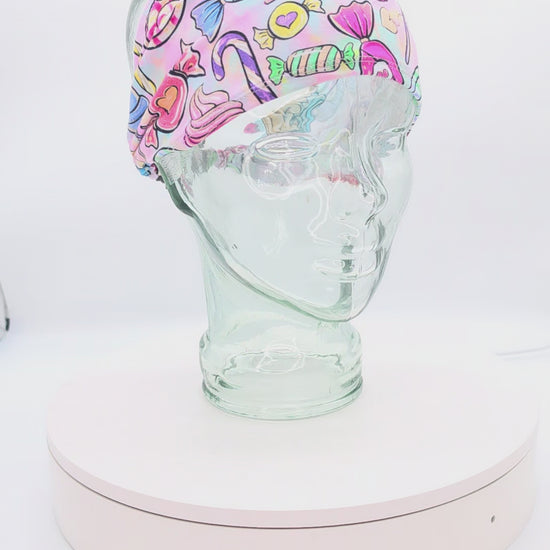 Video showcasing a 360-degree rotating view of the Colorful Candy Wide Headband on a clear mannequin head, highlighting the vibrant sweets pattern and extra wide fit.