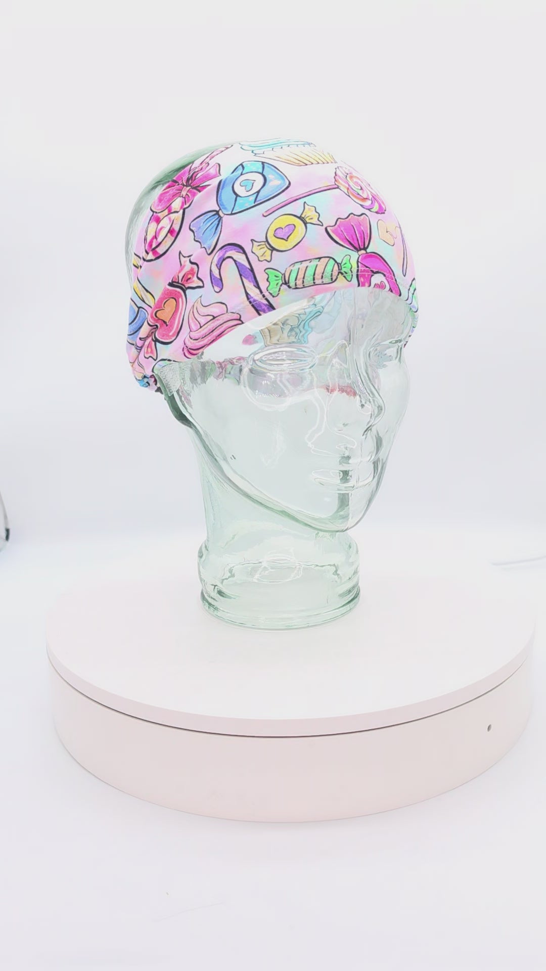 Video showcasing a 360-degree rotating view of the Colorful Candy Wide Headband on a clear mannequin head, highlighting the vibrant sweets pattern and extra wide fit.