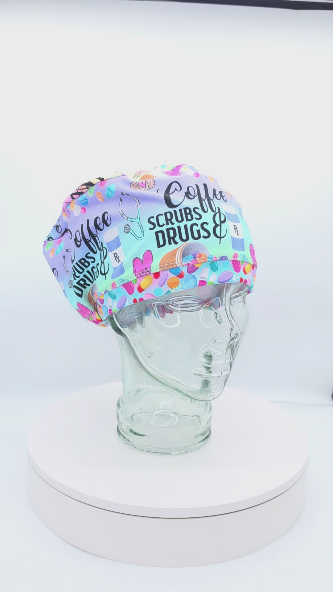 360-degree rotating video of the Coffee Scrubs Drugs Euro-style scrub cap on a clear mannequin head, displaying the pastel medical print, adjustable fit, and full coverage design.