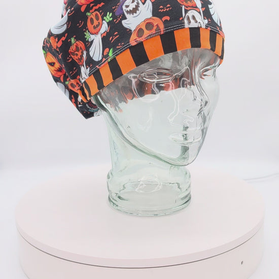 360-degree video showcase of the Pumpkins and Ghosts Scrub Cap rotating on a display mannequin, featuring a spooky Halloween pattern of ghosts and pumpkins