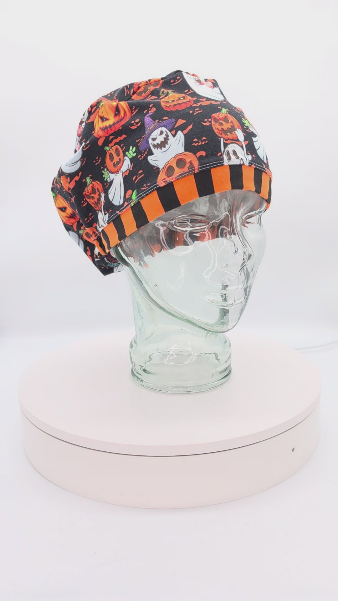 360-degree video showcase of the Pumpkins and Ghosts Scrub Cap rotating on a display mannequin, featuring a spooky Halloween pattern of ghosts and pumpkins
