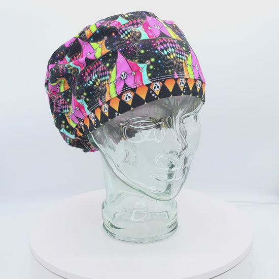 360-degree rotating video of a Spooky Carnival full coverage scrub cap on a display head, highlighting the neon carnival print and rear adjustable toggle.